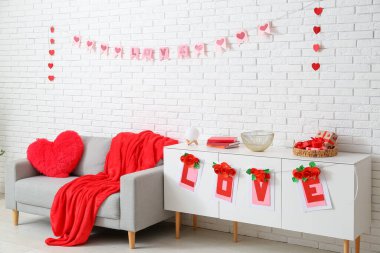 Gri kanepe, kiraz ve kalplerle dolu festival salonunun içi. Sevgililer Günü kutlaması