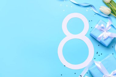 Hediye kutuları ve mavi arka planda güzel laleleri olan 8 numara. Uluslararası Kadınlar Günü