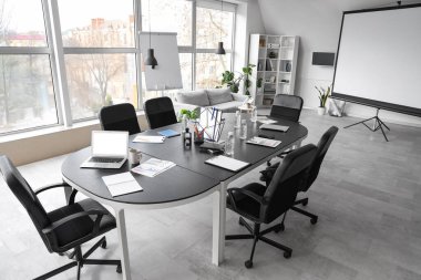 Masa, koltuklar, dizüstü bilgisayar ve kırtasiye konferans salonundaki iş toplantısı için hazırlanıyor.