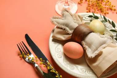 Paskalya yumurtaları, oyuncak tavşancık ve turuncu arka planda mimoza çiçekleri olan güzel bir masa.