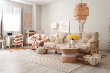 Güzel oturma odasında bir buket narsist çiçekli rahat bir kanepe ve kahve masası.