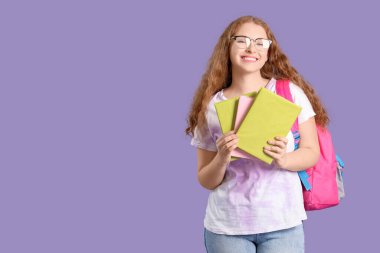 Sırt çantası ve leylak arkaplan kitapları olan düşünceli bir bayan öğrenci.