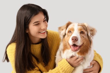 Avustralyalı çoban köpeğini kucaklayan genç bir kadın.