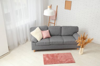 Oturma odasının içinde yastıklar ve otlar olan rahat bir kanepe.