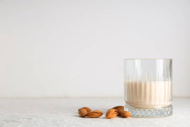 Beyaz arka planda taze badem sütü ve fındık.