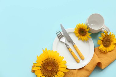 Mavi arka planda ayçiçekleri olan güzel masa ayarları