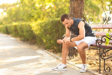 Sportif genç adam antrenmandan sonra nabzını kontrol ediyor.