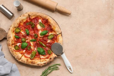 Lezzetli pizzalı kompozisyon ve bej arka planda kesici.