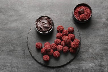 Lezzetli çikolatalı mantarlar ve grunge siyah arka planda bir kase çikolata ezmesi.