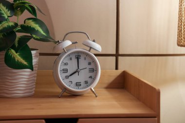 Geceleri yatak odasındaki masada bitkili çalar saat, yakın plan.