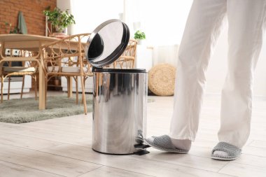 Mutfakta çöp kutusu açan kadın.