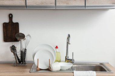 Temiz tabaklar, mutfak aletleri ve lavabonun yanına deterjan koy.