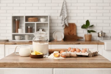 Kavanozda yumurta, bir sürahi süt, mutfak tezgahında hamur hazırlamak için kepçe ve tereyağı.