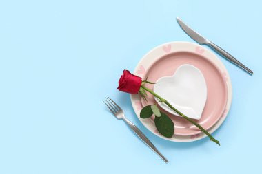Mavi arka planda kırmızı gül olan güzel bir masa. Sevgililer Günü kutlaması
