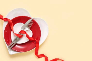 Sarı arka planda kırmızı kurdeleli güzel bir masa. Sevgililer Günü kutlaması