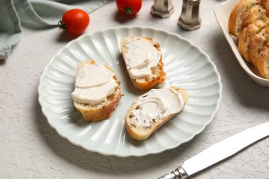 İşlenmiş peynirli lezzetli bruschetta tabağı ve beyaz arka planda taze domatesler.