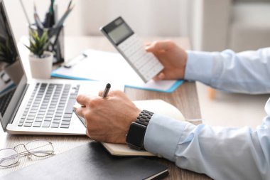 Erkek eller ofiste hesap makinesiyle çalışıyor. Yakın çekim.