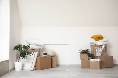 Taşındığı gün odada ışık duvarının yanında olan karton kutular.