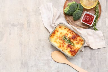 Lezzetli makarna, biberiye, brokoli ve arka planda bir kase ketçap.