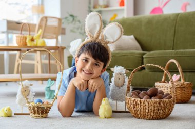 Tavşan kulaklı, sepet sepetinde çikolata yumurtaları, piliçler ve oyuncak koyunlarla oturma odasında yatan sevimli bir çocuk. Paskalya kutlaması