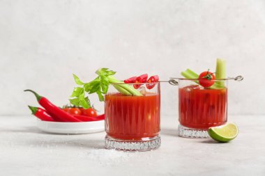 Beyaz arka planda kırmızı biber, kereviz ve limonlu Bloody Mary kokteyli.