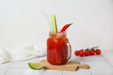Mason kavanozu kırmızı biber, kereviz ve limonlu Bloody Mary kokteyli.