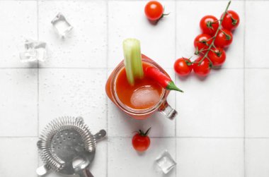 Kırmızı biberli, kerevizli ve beyaz fayanslı buzlu bir kavanoz Bloody Mary kokteyli.