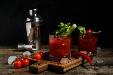 Kanlı Mary kokteyli, kereviz ve ahşap masada kırmızı biber.