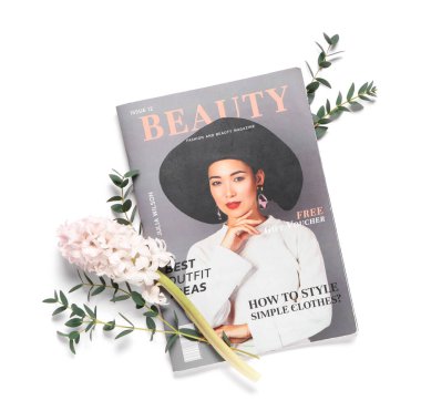 Beyaz arka planda çiçek ve okaliptüs dalları olan dergi