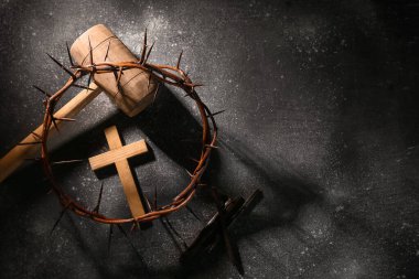 Dikenli taç, haç, tokmak ve gri grunge arka planda tırnaklar