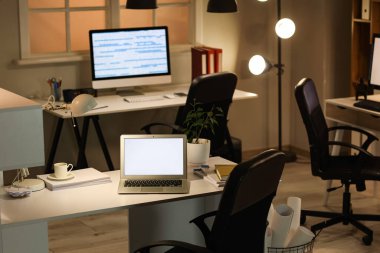 Boş dizüstü bilgisayarı ve parlak lambası olan bir işyeri.