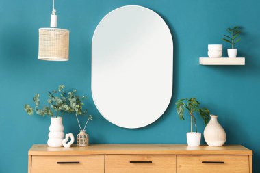 Çekmeceler, ev bitkileri ve mavi duvardaki ayna. Yakın çekim.