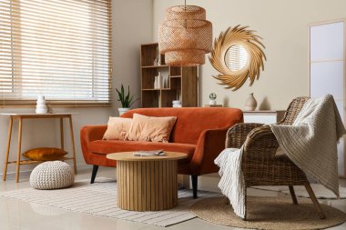 Modern oturma odasının içinde kahverengi kanepe, raf ünitesi ve şık bir ayna var.