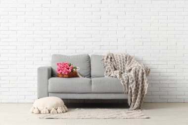 Gri kanepede güzel lale çiçekleri olan şık bir oturma odası.