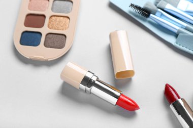 Açık arkaplanda güzel ruj ve göz farı, yakın plan.