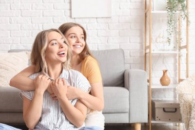 Genç kız kardeşler evde sarılıyorlar.