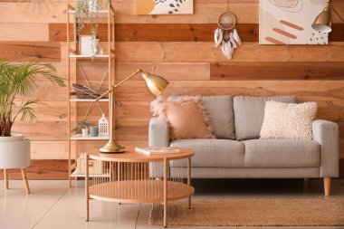 Kanepesi, raf ünitesi ve ahşap duvarda asılı düş kapanı olan modern oturma odasının içinde.