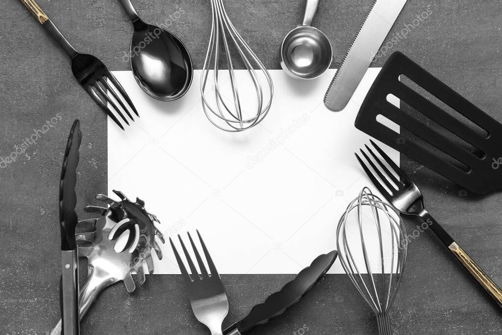 Frame made of blank card and different cutlery on grey background