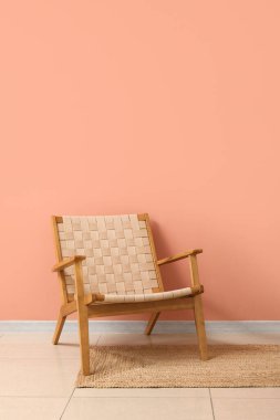 Pembe duvarın yanında rahat koltuk ve hasır halı.