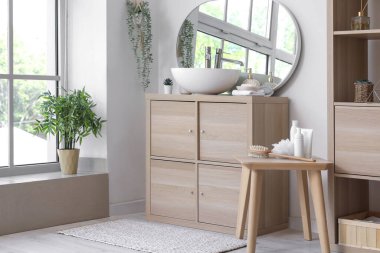 Lavabo lavabosu ahşap dolapta, aynada ve raf ünitesinde.