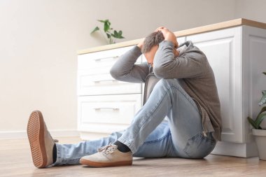 Olgun bir adam mutfakta panik atak geçiriyor.