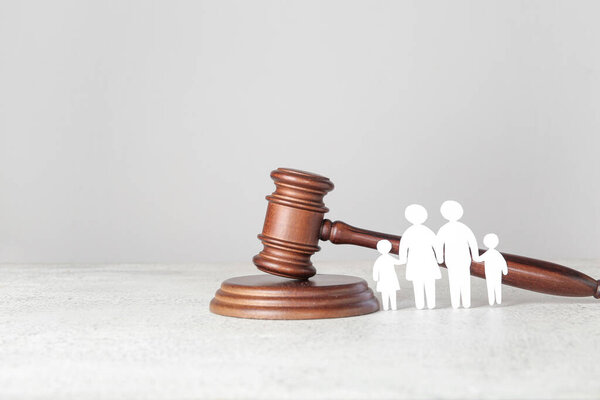 Фигуры семьи с молотком судьи на светлом столе