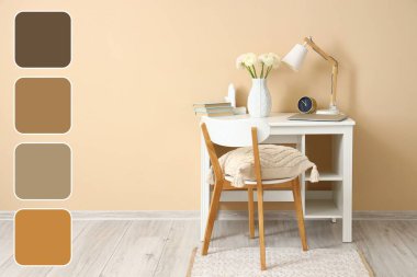 Bej duvarın yanında ranunculus çiçekleri olan rahat bir iş yeri. Farklı renk desenleri