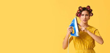 Stresli kadın sarı arkaplanda demire dokunuyor ve metin için boşluk var.