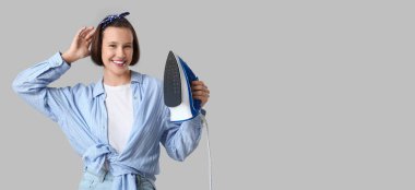 Gri zemin üzerinde demir olan genç bir kadın ve metin için yeri var.