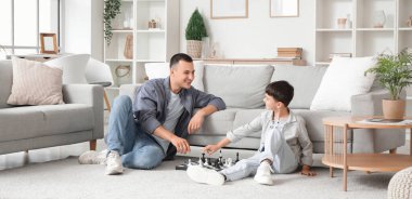 Babasıyla evde satranç oynayan tatlı bir çocuk.