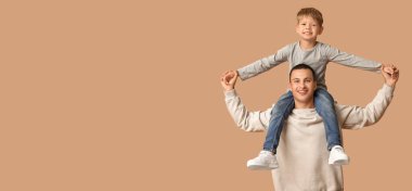 Mutlu baba ve küçük oğlu bej arka planda eğleniyorlar ve mesaj için yer var.