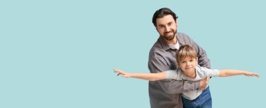 Açık mavi arka planda oynayan mutlu baba ve oğulun portresi. Babalar Günü.