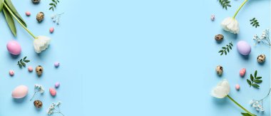 Paskalya yumurtalarından, yeşil yapraklardan ve açık mavi arka planda çiçeklerden yapılmış çerçeve