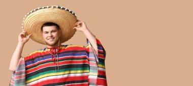 Sombrero ve pançolu mutlu genç adam bej arka planda ve mesaj için yeri var.